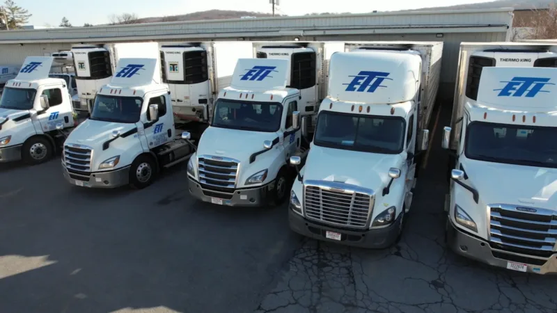 A row of five ETI Trucking temperature control trucks that have Thermo King temperature control units on the front of the trailer